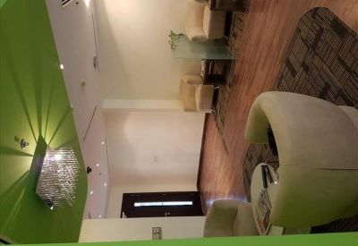 Communal lounge area with curved armchairs and a green ceiling element.
