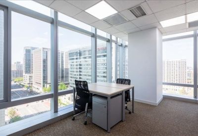 Two-person window office suite with natural light and grey pedestal storage.