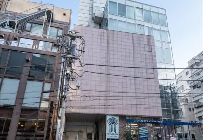 Street view of the modern multi-story Fuji building 40 with retail on the ground floor.
