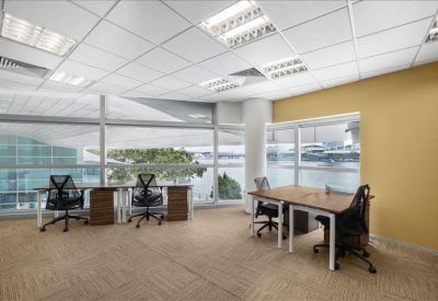 Spacious open-plan office with ergonomic chairs and large windows.