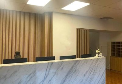 Reception area featuring a large marble desk and vertical wooden slat wall feature.