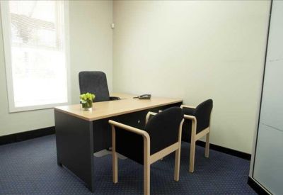 Private office space with a wooden desk and two guest chairs.