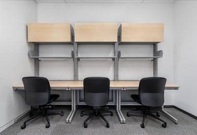 Compact three-person workstation with overhead cabinets and shelving.