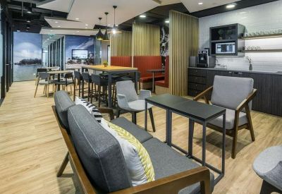 Vibrant communal lounge and kitchen area with stylish wooden furniture and breakout seating.