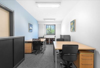 Multi-desk private office suite with blue accent wall and natural light.