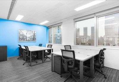 Bright office suite with six workstations and a blue feature wall.