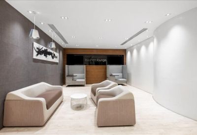 Lounge area with comfortable beige sofas, a circular coffee table, and minimalist wall art.