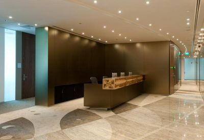 Modern reception area with a minimalist dark desk and warm overhead lighting.