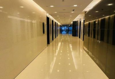 Bright corridor with shiny tiled flooring and ceiling lights.