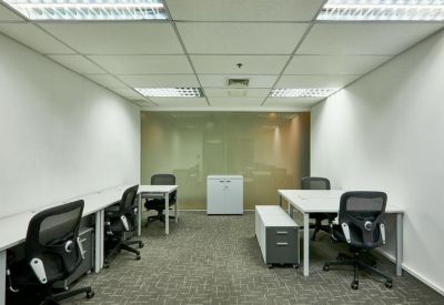 Bright open-plan office suite with white desks and ergonomic black chairs.