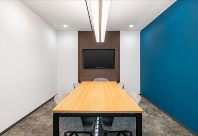 Symmetrical meeting room with a long wooden table, dark feature wall, and blue accent wall.
