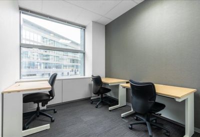 Bright private three-person office suite with grey feature wall and large window.