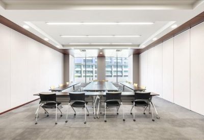 Spacious training room with tables arranged in a U-shape and bright overhead lighting.