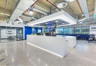 Spacious white reception desk under a modern rectangular light fixture.