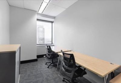 Private windowed office with two desks and ergonomic black chairs.