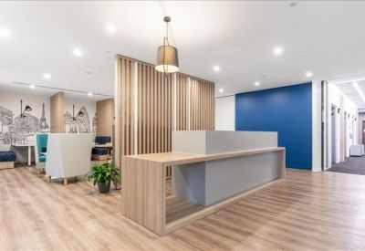 Modern reception area with a wood-fronted desk and decorative timber slat partition.