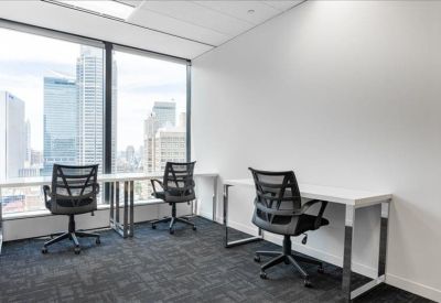 Private office with white desks and floor-to-ceiling windows showing city views.