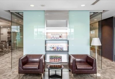 Sleek waiting area with leather armchairs set against a pale blue feature wall.
