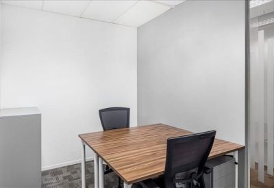 Minimalist internal two-person office suite with a wooden desk and grey partition wall.