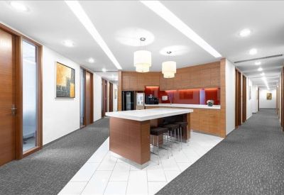 Spacious communal kitchen area with a large central island, breakfast bar stools, and wood cabinetry.
