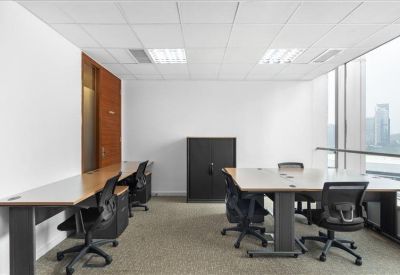 Bright corner office with long wooden desks and views through large windows.