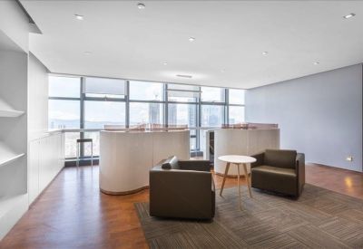 Lounge area with dark armchairs and curved white service counters by large windows.