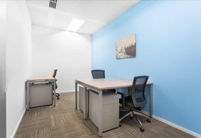 Private office featuring a light blue accent wall and two separate desk setups.