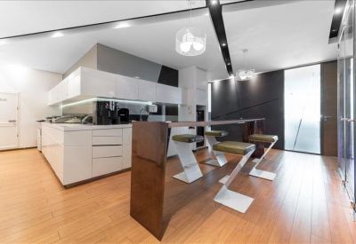 Contemporary office kitchen and breakout area with high-top bar seating.