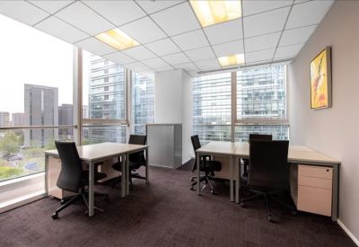 Spacious shared office with two desk clusters and floor-to-ceiling windows.