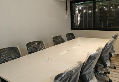 Long meeting table with chairs wrapped in protective plastic.