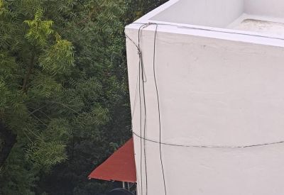 Exterior view of the building corner with signage visible among trees.