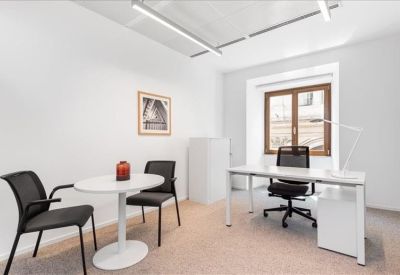 Private internal office suite with a white desk and guest seating.