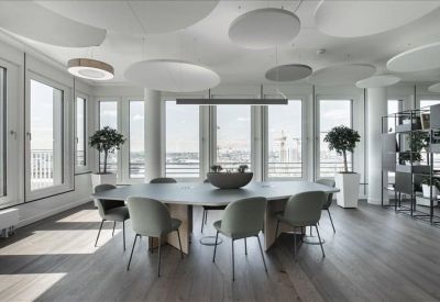 Spacious boardroom with a large oval table and modern acoustic ceiling panels.