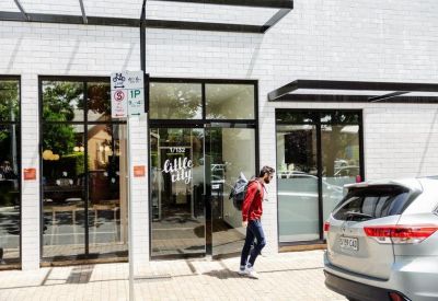 Entrance of the white brick building at 1/ 132 Prospect Road with glass doors and street signage.