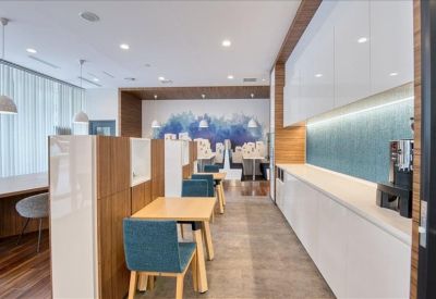 Communal break area with a white kitchenette and cafe-style seating.