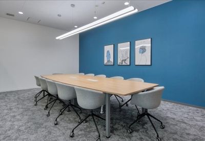 Large conference room with a long wooden table and light blue feature wall.