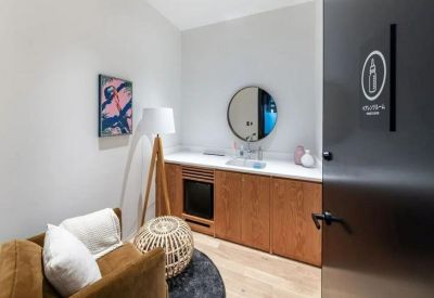 Private wellness room with a wooden vanity, mirror, and comfortable seating.
