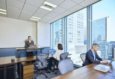 Bright office space with standing desks and large windows overlooking the city.