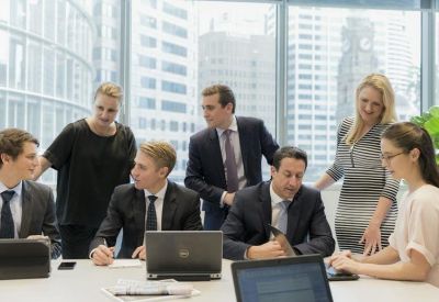 Collaborative team meeting in a bright glass-walled office with city views.
