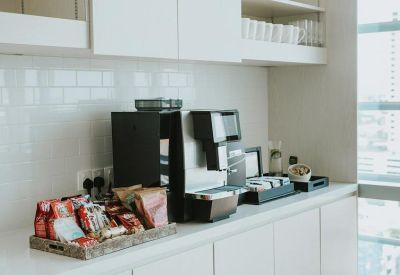 Coffee machine and snack tray in a modern office pantry area.