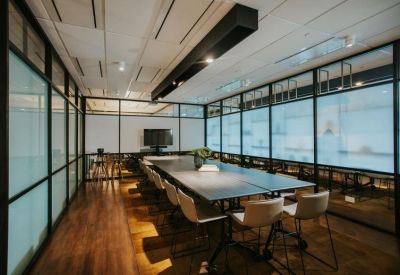 Professional meeting room with a long dark table and glass partitions.