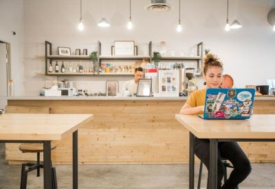 Bright cafe area featuring a wooden bar counter and pendant lighting.