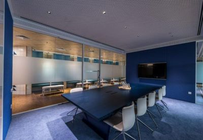 Professional meeting room with a dark blue feature wall and a large black table.