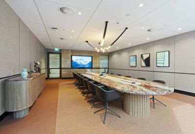 Elegant boardroom featuring a large marble table, designer lighting, and framed artwork.