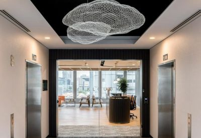 Elevator lobby with dark ceiling and cloud-like wire mesh pendant lights.