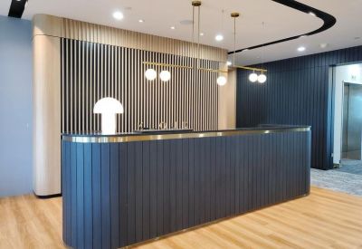 Modern reception area at 1, Pickering Street, Singapore featuring a blue slatted desk and globe lighting.