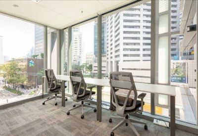 Window-facing workstations with grey ergonomic chairs and city views.