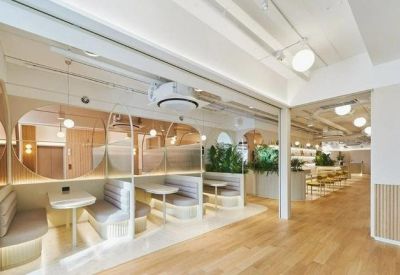 Private white seating booths separated by glass partitions in a bright hallway.