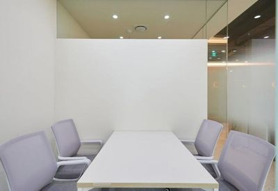 Compact meeting room with a white table and four chairs.