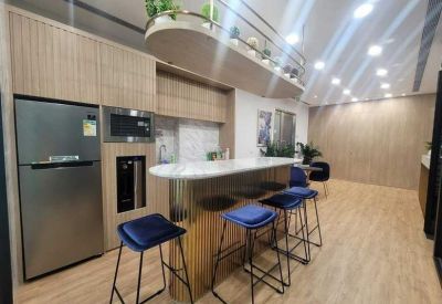 Communal kitchen and break area with a marble breakfast bar and blue velvet stools.
